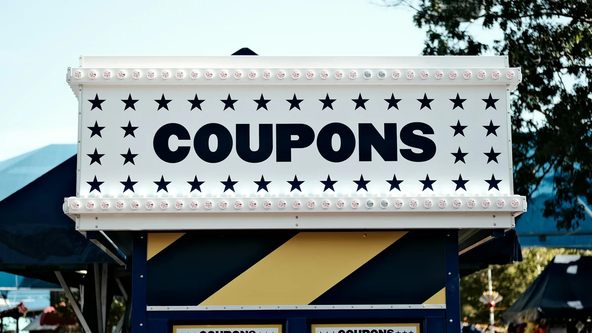 Una caseta de feria con un letrero grande que dice COUPONS