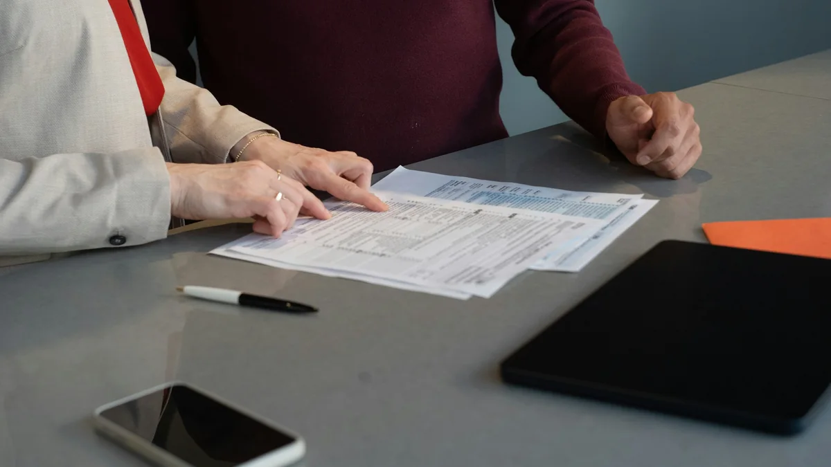 Dos personas revisando juntas un formulario en papel sobre una mesa